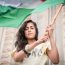 A young woman holds a Palestinian flag at a Combatants for Peace rally outside Bethlehem | Photo by: John McColgan | Via: Flickr | Licensed under: CC BY 2.0