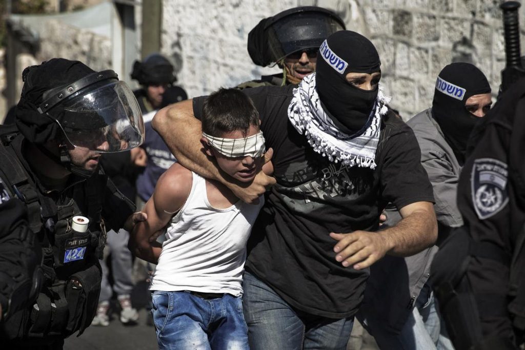 A Palestinian child dragged by his neck by an undercover Israeli militant | Photo via: Addameer.org