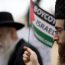 Haredi Jew holding a Palestinian flag with the text 